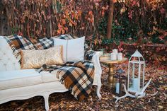 a white couch sitting next to a table on top of leaves