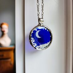 If you're into unique pieces, you'll love this fidget pendant necklace for women. It's a floating pendant featuring moon and stars with free moving stars that are just mesmerizing. There's even a must see video that shows off how cool it looks in action. This celestial jewelry makes a perfect gift for wife--she'll love the playful and cosmic vibe! Pocket watch crystals are durable and make the perfect glass in which to encase small things. This one is combined with cobalt blue stained glass. Encased is a silvery moon with small stars that move freely Fun! Check out the video! * Pendant: 2 inch H x 1 1/2 inch W * Shiny Silver Finish * Fidget Shaker Necklace * Select your length of fully adjustable figaro chain with secure lobster claw clasp * Truly Hand Made in USA at my home studio in Loui Celestial Pendant Necklace Gift For Her, Celestial Pendant Necklace As A Gift For Her, Celestial Necklaces With Adjustable Chain As Gift, Celestial Round Pendant Necklace For Gifts, Celestial Necklace With Adjustable Chain Gift, Celestial Style Round Pendant Necklace For Gift, Celestial Pendant Locket Jewelry, Celestial Round Pendant For Jewelry Making, Celestial Necklace With Large Round Pendant