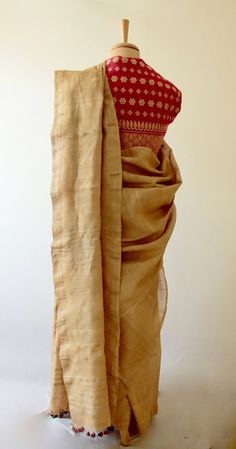 This is a Handloom, Hundred Percent Pure Muga Silk Saree from the looms of ASSAM.  The Saree is more contemporary than traditional as it has been woven in the lightweight manner so that it is easier to wear and handle. There are small all over motifs in muga ghicha . It is very subtle .  Muga Silk - The most valued silk from India. Almost exclusively reared and produced in Assam, India. It is indigenous to the Brahmaputra Valley and assiduously practiced in the districts of Assam. The moth is ba Festive Woven Motifs Blouse, Elegant Blouse Piece For Puja With Weaving Work, Elegant Blouse Piece With Weaving Work For Puja, Traditional Ceremonies Woven Motifs Blouse Piece, Elegant Blouse Piece With Woven Motifs For Festive Occasions, Elegant Festive Blouse Piece With Woven Motifs, Traditional Drape Blouse With Woven Motifs, Traditional Fitted Beige Saree, Festive Red Blouse Piece With Weaving Work