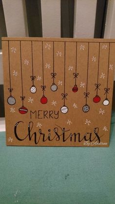 a christmas card with ornaments hanging from it