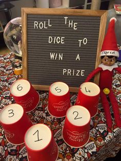 a table with red cups and a sign that says roll the dice to win a prize