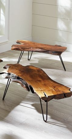 two wooden benches sitting on top of a hard wood floor next to each other in front of a window