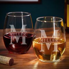 two wine glasses sitting on top of a wooden table