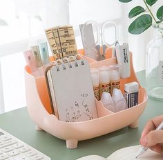 a person is writing on a notepad in front of a desk with a keyboard