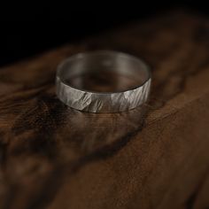 a silver ring sitting on top of a wooden table