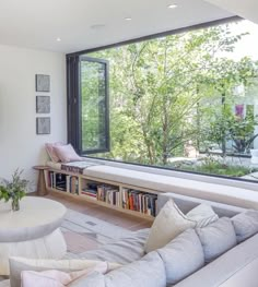 a living room filled with furniture and a large window next to a wall mounted tv