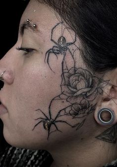 a woman with a spider tattoo on her neck and behind her ear is a rose