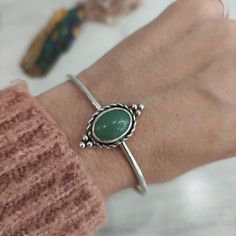 "This sterling silver cuff is completely handmade in our workshop, such as all our products.  The thickness of wire is 2,5mm and the stone is a green natural aventurine.q The sizes we offer below refer to wrist measurement. If you want other size, please send me a message before your purchase. All my items are handmade from start to finish in Greece. Come in a beautiful gift package with \"κοσμώ\" message card.  Thank you for visiting, check my full collection here: https://www.etsy.com/shop/kosmojewellery HOW TO CARE FOR YOUR STERLING SILVER JEWELLERY: Any substance that isn't PH neutral can potentially affect your jewellery. Cosmetics, perfumes, lotion and everything that contains chemicals can damage your jewellery. So, I recommend that you always make sure to take off your jewellery be Aventurine Bracelet, Men Bracelets, Pink Tourmaline Ring, Form Design, Gift Package, Sterling Silver Cuff Bracelet, Gold Hands, Statement Bracelet, Stunning Necklace