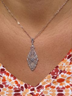 The Toomavara Ladies White Gold Filigree Camphor Glass Necklace set with Diamond. Delicately crafted in white gold, this vintage necklace features intricate filigree designs draped over camphor glass. Complete with an accent diamond, this pendant dangles from a 16 inch white gold chain. The chain can be swapped for another length chain for an additional charge. Each piece has been hand selected and meticulously identified and graded by a Graduate Gemologist who has been awarded a degree by the G White Gold Chain, White Gold Necklace, White Gold Chains, Filigree Design, Gold Filigree, Glass Necklace, Wedding Necklace, Vintage Necklace, Gold Chain