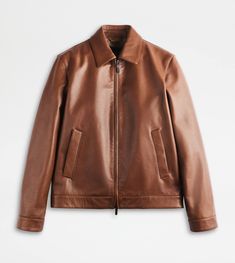 Jacket in soft leather with shirt collar. Featuring two slanted welt pockets and a double-slider zip, it is enriched by refined iconic detailing: the rectangular leather patch on the back with stamped Tod's logo and shaped zip pulls, inspired by the historic Greca Belt buckle. Leather Shirt Jacket, Dark Brown Leather Jacket, Brown Leather Jacket Men, Italy Shirt, Zip Puller, Brown Shirt, Caramel Brown, Leather Shirt, Balenciaga Triple S