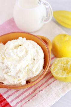 a bowl filled with whipped cream next to sliced lemons