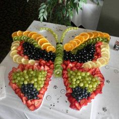 a butterfly made out of fruit sitting on top of a table