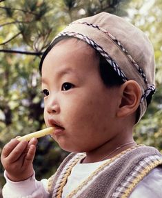 a young child is eating something with a stick