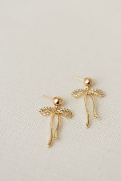 Rumor has is that 2024 is the year of BOWS! These super cute, dangly bow earrings will be the HIT of any party. Includes two gold or silver-plated dangly bows 6mm 14k gold-filled + sterling silver, hypoallergenic ball studs Choose from either solid or sparkly Gold Dainty Bow Earrings, Gold Dainty Earrings With Bow, Dainty Gold Earrings With Bow, Gold Dangle Jewelry With Bow, Yellow Gold Earrings With Dangling Charms For Gift, Dainty Gold Bow Earrings, Yellow Gold Earrings With Dangling Charms As Gift, 14k Gold Bow Jewelry, Dangle Bow Earrings For Gift