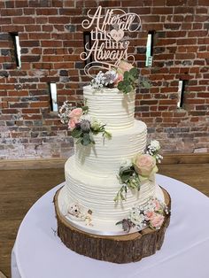 a wedding cake sitting on top of a white table next to a red brick wall