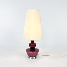 a lamp that is on top of a white surface with a light bulb attached to it