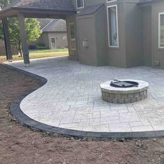 a brick patio with a fire pit in the middle