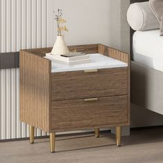 a night stand with two drawers on each side and a white bed in the background