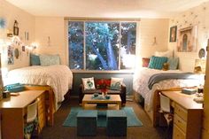 a bedroom with two beds, a couch and a coffee table in front of a window