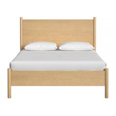 a bed with white pillows and wooden headboard on top of it's frame