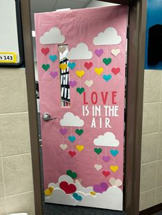 a pink door decorated with hearts and the words love is in the air