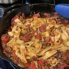 a skillet with some pasta and meat in it