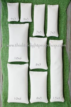 six white pillows laid out on a green mat with numbers in each one and the other four