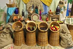 several wicker baskets filled with fruit on top of a table covered in cloths