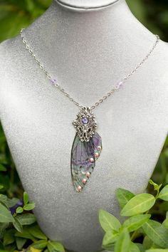 The Sebille Fairy Wing necklace is made with our purple and green speckled ombre' mini fairy wings and accented with Swarovski rhinestones and a filigree silver stamping. Wings 2" LongThis necklace is so stunning in person, we combined our love art nouveau and fairy magic to create this unique necklace.No Fairies were harmed in the making of this jewelry. The wings are harvested during the fall molt.We ship rush and internationally.Send us a message to inquire about prices.We also make these in Handmade Purple Fantasy Necklaces, Handmade Purple Fantasy Necklace, Silver Winged Fantasy Jewelry, Handmade Purple Fairycore Jewelry, Silver Wing-shaped Fantasy Jewelry, Silver Fantasy Wing-shaped Jewelry, Fantasy Silver Wing-shaped Jewelry, Purple Fairycore Jewelry For Gifts, Fairycore Purple Jewelry As A Gift