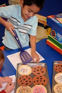 two children at a table making decorated cookies