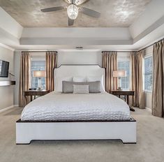 a bedroom with a large bed and ceiling fan