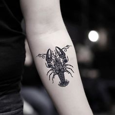 a black and white photo of a lobster tattoo on the left arm with an intricate design