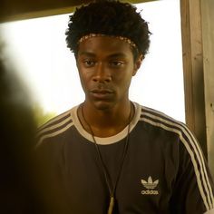 a young man with an afro is looking at the camera while wearing a headband