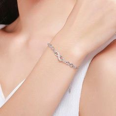 Upgrade your fine jewelry collection with this stunning Chain of Infinity bracelet. Crafted with love and care, this sterling silver bracelet features the timeless infinity symbol adorned with sparkling cubic zirconia gems. The platinum plating gives it a luxurious finish, ensuring long-lasting shine. Perfect as a gift for a loved one or a beautiful addition to your everyday wear. Materials: 925 sterling silver, cubic zirconiaFinish: platinum plateBracelet length: 6 + 2 inches. Jewelry Care: See Silver Infinity Diamond Bracelet For Formal Occasions, Silver Infinity Jewelry With Cubic Zirconia, White Gold Infinity Jewelry With Cubic Zirconia, White Gold Infinity Cubic Zirconia Jewelry, Silver Infinity Diamond Bracelet For Anniversary, Dainty Cubic Zirconia Infinity Jewelry, Dainty Infinity Cubic Zirconia Jewelry, Elegant Infinity Cubic Zirconia Jewelry, Anniversary Infinity Bracelet In Cubic Zirconia