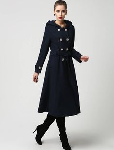 "This beautiful long wool coat features a double-breasted bodice and oversized silver buttons to create a distinct but classic military style. this winter coat features gorgeous navy blue wool, a polyester lining, and fun features like extra long sleeves, deep side pockets and back split vents. The self-tie belt makes it easy to accentuate your waist while the warm hood will stylishly shield you from the cold. DETAIL * 50% WOOL,50% POLYESTER * POLYESTER LINING * Epaulette with button * with warm Spring Long Peacoat With Buttons, Spring Peacoat With Buttons, Elegant Spring Peacoat With Buttons, Winter Double-breasted Wool Coat With Button Closure, Double-breasted Wool Coat With Buttons For Winter, Double-breasted Winter Peacoat With Buttons, Winter Long Pea Coat With Buttons, Elegant Winter Double-breasted Peacoat, Elegant Blue Wool Coat With Buttons