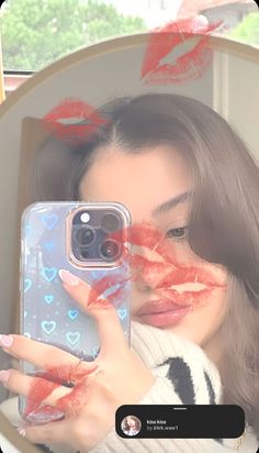 a woman taking a selfie with her cell phone in front of her face and red lipstick on her lips