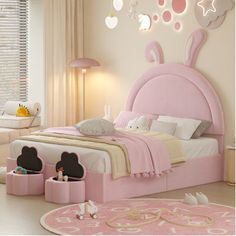 a child's bedroom decorated in pink and white with bunny ears on the headboard