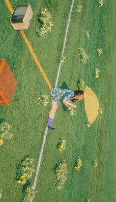 a woman laying on the ground with an umbrella in front of her and other items around her