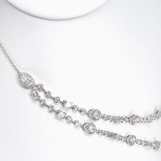 The Statement Opera Two Row Multi-Shape Halo Diamond Station Necklace is a breathtaking embodiment of luxury and elegance. This exquisite piece of jewelry is a true work of art, meticulously crafted to exude sophistication and charm. At the forefront of this necklace are two opulent rows adorned with an array of diamonds featuring various shapes. Each marquise diamond is encircled by a delicate halo, enhancing its brilliance and creating an ethereal glow. The combination of different diamond shapessuch as round brilliants, marquise and emerald cutsadds a captivating allure, capturing the eye with its symphony of shapes and sparkle. Luxury Diamond Cut Station Necklace For Formal Occasions, Luxury Brilliant Cut Diamond Station Necklace, Luxury White Gold Marquise Diamond Necklace, Luxury Elegant Marquise Necklace, Luxury Marquise Cut Diamond Necklace, Luxury Diamond Necklace With Jewels For Anniversary, Formal Diamond Necklace With Jewels, Luxury Diamond-cut Necklace For Evening, Luxury Diamond Cut Necklaces For Evening