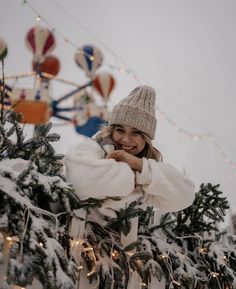 a woman standing next to a christmas tree