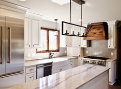 a kitchen with marble counter tops and white cabinets