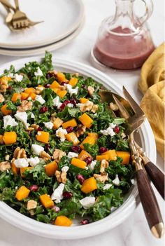 a white plate topped with a salad covered in feta cheese and pomegranate