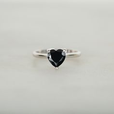 Heart cut Black Simulated Diamond Ring ♦ Handmade, high-quality item (Made to order) ♦ Material:925 Sterling silver (can be made in Solid white/rose/yellow gold) ♦Finish:  High Polishing Finish with Rhodium platting ♦ Center stone: Black Simulated Diamond (Black Cubic Zirconia) ♦ Size/Weight: Heart cut 7x7 mm  ♦ Color: Black ♦ Width of band bottom - 2.0 mm ♦ Thickness of the gold band - 1.28 mm Customization is available, feel free to contact me Black Rings For Women Simple, Black And Silver Rings, Black Heart Ring, Knife Edge Engagement Ring, Heart Diamond Engagement Ring, Heart Solitaire Ring, Black Spinel Ring, Gold Pinky Ring, Black Onyx Engagement Ring