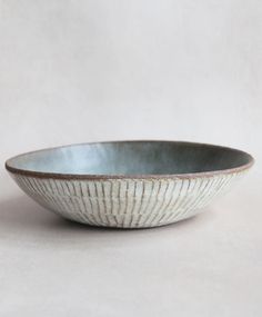 a white bowl sitting on top of a table next to a brown and white wall