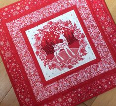 a red and white quilt with a deer on it