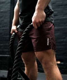 a man holding a rope while wearing shorts