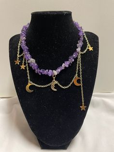 Estela is our amethyst, gold, and moon charm necklace.  ~It is made with a variety of star and moon charms. The necklace is made of gold chains and is brought together by a lobster clasp.  ~This necklace has extra chain so size adjustments can be made if needed.  ~Please choose either the sun or moon as the middle charm.  ~All of our necklaces are handmade Product Care:  -Apply beauty products such as perfume, hairspray or deodorant before wearing your jewelry as certain chemicals in these products may damage the finish. -Always remove your jewelry before swimming, bathing, doing household chores or using abrasive cleaners  If you have any questions let us know and we will be happy to answer them. Have a nice day! Adjustable Purple Celestial Jewelry, Purple Adjustable Celestial Jewelry, Handmade Celestial Amethyst Necklace, Mystical Purple Necklace For Festivals, Celestial Amethyst Purple Necklace, Celestial Purple Amethyst Necklace, Adjustable Purple Moon Phase Jewelry, Mystical Dangle Necklaces With Moon Charm, Adjustable Celestial Amethyst Jewelry