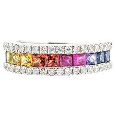 a multicolored ring with diamonds on the bottom and sides, set in 18k white gold