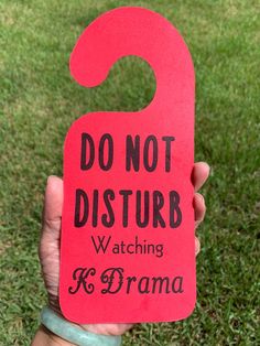 a person holding up a red sign that says do not disturb watching r & d drama