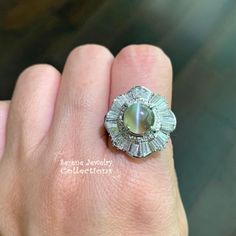 Pretty chrysoberyl cats eye diamond platinum vintage ring! The chrysoberyl has a white cats eye down the center, and is surrounded by waves of diamond baguettes totaling 1.23 carats! Ring Size: 7.5 Total Weight: 14.3 grams Precious Metal: Platinum Precious stones: -Cats Eye Chrysoberyl Center Stone: 3.48 carats, 8.6mm -White Tapered Baguette Diamonds: 1.23 carats Hallmark: 3.48, 1.23, Pt900 Cat Diamond Ring, Platinum Diamond Rings, Big Diamond, Baguette Diamonds, Cats Eye, White Cats, Platinum Ring, Precious Metal, Baguette Diamond